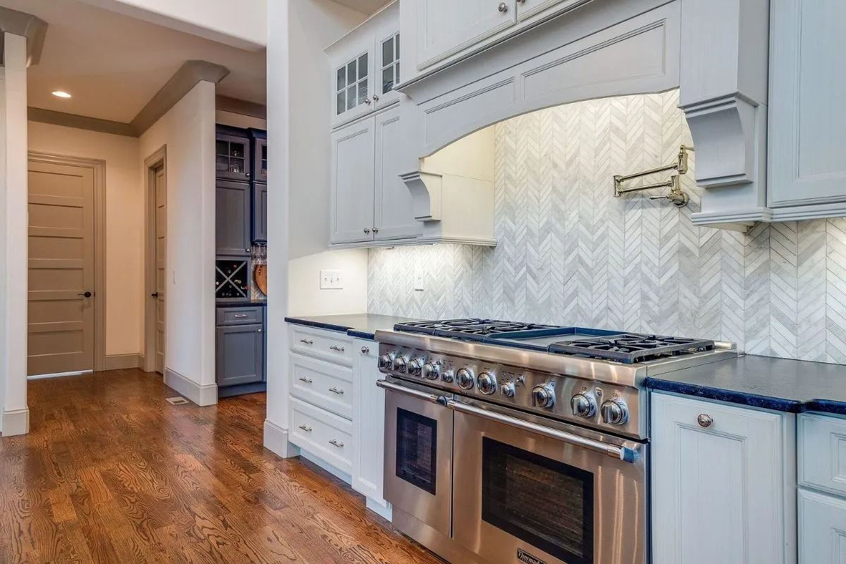 Range wall with a herringbone tile backsplash