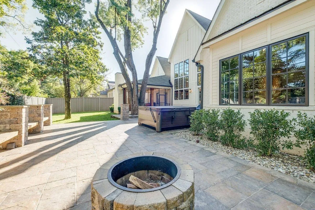 Back patio with a stone fire pit and seat walls