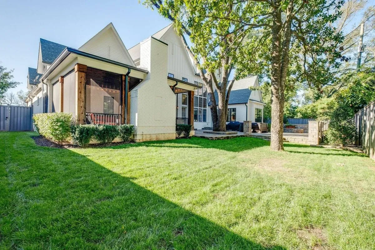 Backyard lawn and the screened porch with its brick fireplace