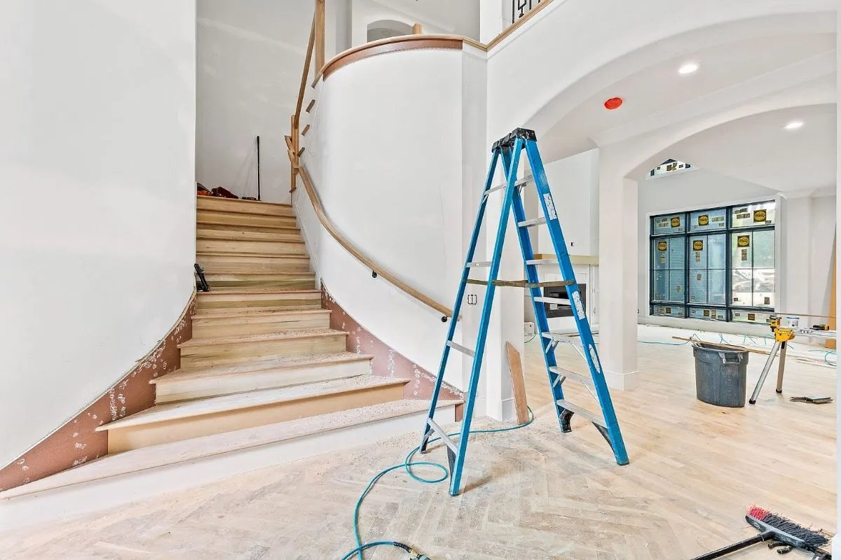 Curved staircase during finishing, with a ladder still in place