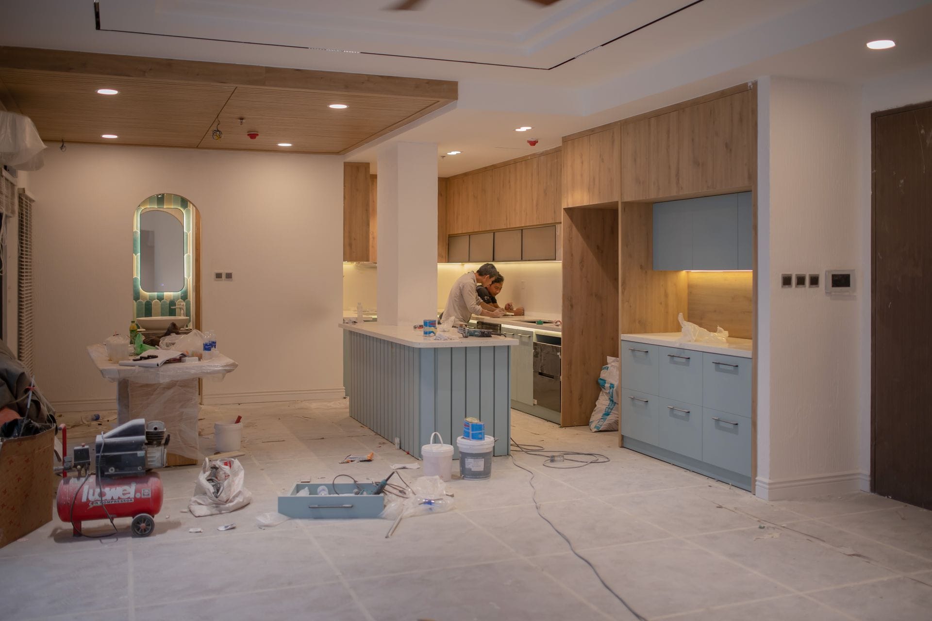 Kitchen mid-remodel with new cabinets and an island installed, tools and materials still on the floor